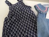 a baby girl ' s dress and a baby boy ' s overalls