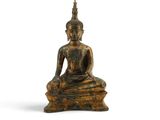 une image représentant une statue d'une personne assise sur un rocher