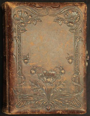 un vieux livre dont la couverture est ornée d'un motif floral