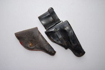 two leather holsters on a white surface