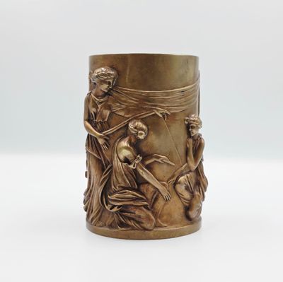 une image représentant un vase en laiton orné d'un motif représentant une femme et un homme
