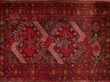 an old persian rug with a red and black design