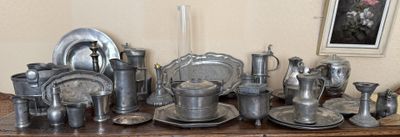 une table sur laquelle sont disposés plusieurs assiettes et tasses en argent