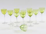 sept verres à vin alignés sur une surface blanche