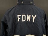 the back of a navy jacket with the word fdny written on it