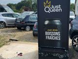 cars parked in a parking lot next to a black trash can
