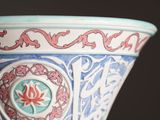a blue and white vase with a red design on it