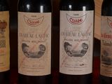 three bottles of red wine are lined up on a table