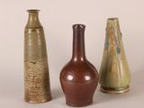 three vases sitting next to each other on a white surface