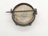 a small metal object on a white surface with a stick in it