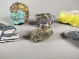 five different colored rocks on a white surface