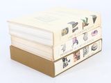 three books stacked on top of each other on a white surface