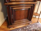 a tall wooden cabinet with a clock on top of it