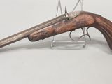 un vieux fusil exposé sur une surface blanche