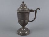 an antique silver teapot with a lid and handle on a stand