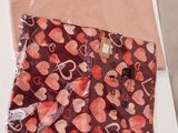 two bags with hearts printed on them on a table