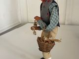 a figurine of a man with a basket of flowers