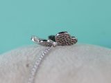 a silver ring with a heart on it sitting on a pillow