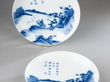 pair of blue and white plates with figures in a landscape