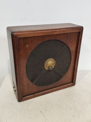 une vieille horloge en bois avec un cadran noir sur un fond blanc
