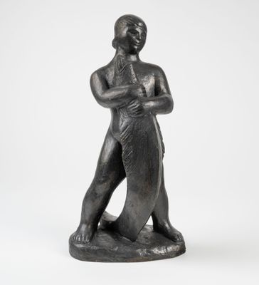 a black statue of a man holding a surfboard on a white background