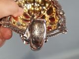 a person holding a silver and gold object in their hand