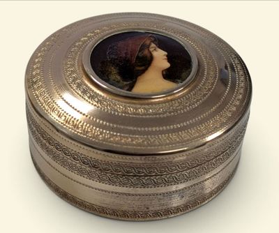une boîte en argent sur laquelle figure le portrait d'une femme