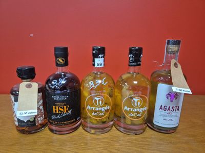 Plusieurs bouteilles d'alcool sont alignées sur une table en bois