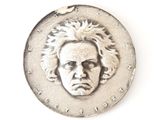 a silver coin with a face of a man on it