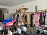 un présentoir de vêtements dans un magasin de mode, avec une tête de mannequin posée sur l'étagère