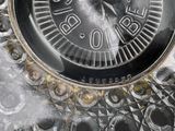 a close up of a clock on a glass plate
