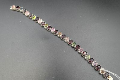 un gros plan sur un bracelet orné de nombreuses pierres de différentes couleurs