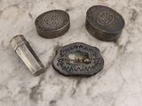 un petit objet métallique posé sur une table en marbre, à côté d'autres objets