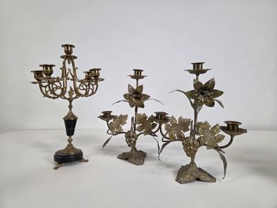 three antique brass candelabs with flowers and leaves on them