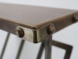 a close up of a metal table with a brown top