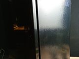a black refrigerator sitting on top of a wooden table