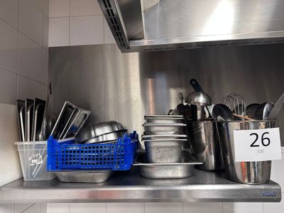 de nombreuses casseroles et poêles sur l'étagère de la cuisine