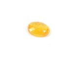 a close up of a yellow sapphire stone on a white surface