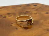une photo d'une bague en or posée sur une table en bois