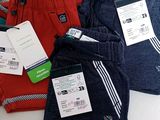 several pairs of men ' s sweat pants with tags on them