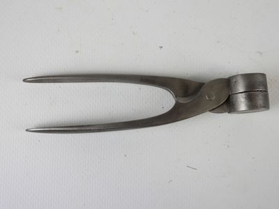 une paire de pinces posée sur une table, sur fond blanc