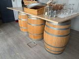 a wooden table with wine glasses and a basket on top of it