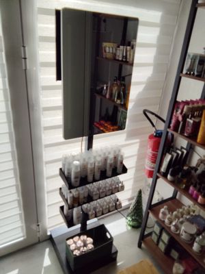 une étagère avec des flacons de produits cosmétiques et un miroir dans la pièce