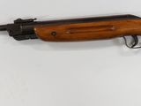 rifle mounted on a wall in a room with a white wall