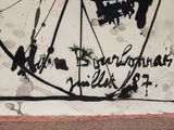 a painting of a bicycle on a wall with writing on it