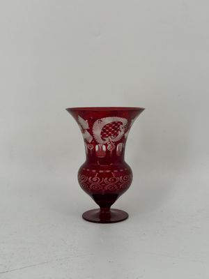 une image représentant un vase en verre rouge sur fond blanc