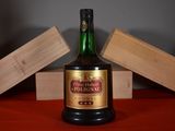 a bottle of liquor sitting on a table next to a block of wood
