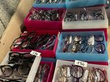 many pairs of eyeglasses in the boxes on the table