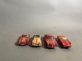 four toy cars are lined up in a row on a table