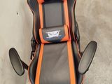 a black and orange gaming chair sitting in a garage